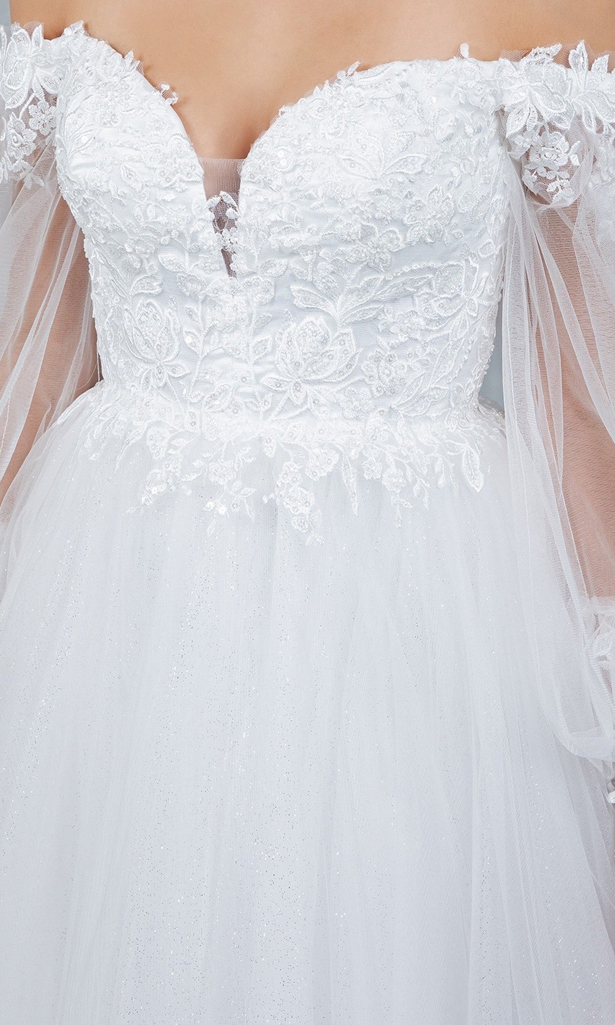 Close-up of the Cinderella Couture 4233 long formal dress featuring a white, off-the-shoulder lace design with an embroidered bodice, sheer tulle sleeves, and delicate floral embroidery.